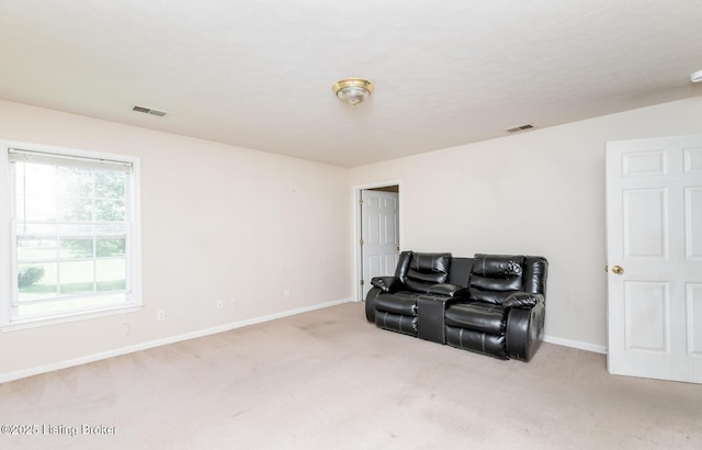 living area with baseboards, carpet, and visible vents
