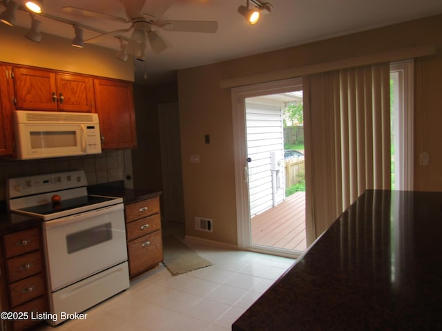 11802 Running Creek Rd, Douglass Hills, KY 40243 - kitchen with white appliances, track lighting, dark countertops, brown cabinets, and decorative backsplash