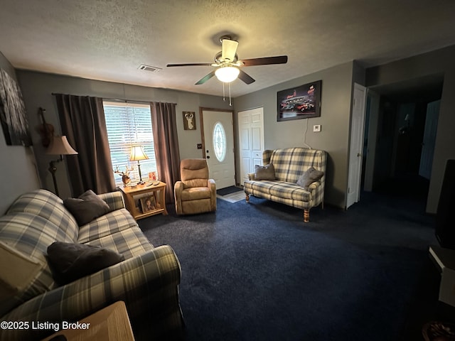 carpeted living area with visible vents, a textured ceiling, and ceiling fan