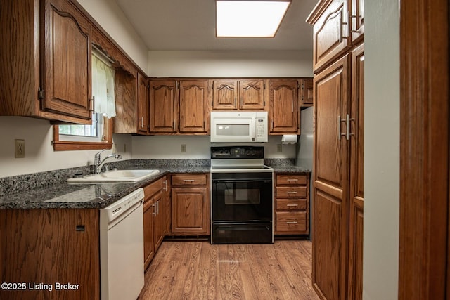 4217 Deckard School Rd, Radcliff, KY 40160 - kitchen with white appliances, a sink, dark countertops, light wood-style floors, and brown cabinets