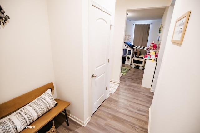 corridor featuring baseboards and light wood-type flooring