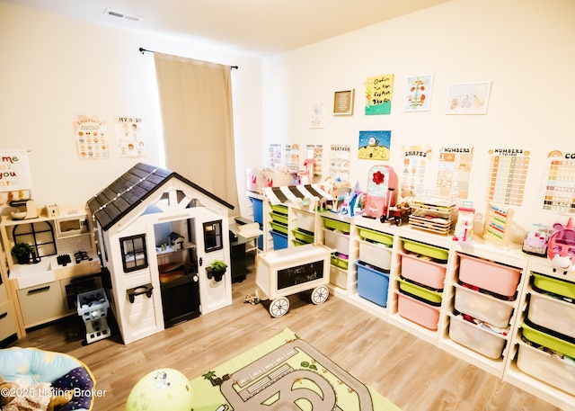 playroom featuring visible vents and wood finished floors