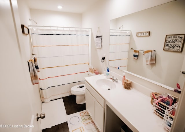 bathroom featuring recessed lighting, wood finished floors, a shower with curtain, toilet, and vanity
