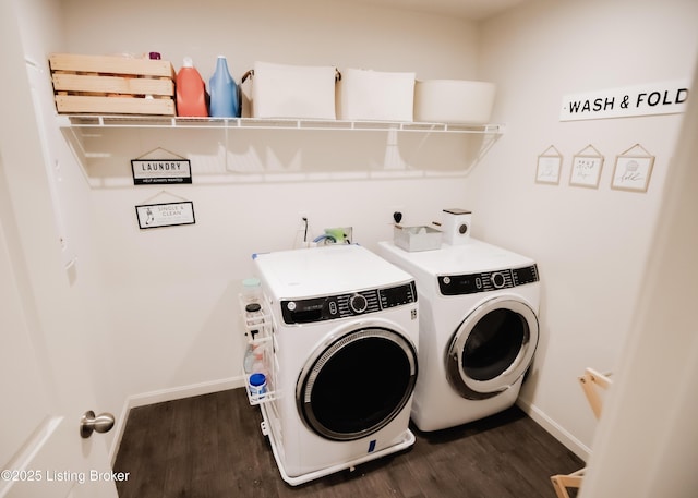clothes washing area with baseboards, washer and dryer, dark wood-style flooring, and laundry area