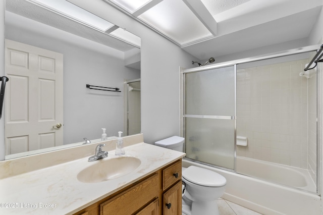 bathroom with vanity, shower / bath combination with glass door, tile patterned flooring, and toilet
