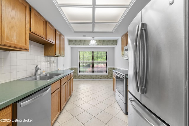 kitchen with decorative light fixtures, brown cabinets, a sink, stainless steel appliances, and light tile patterned flooring