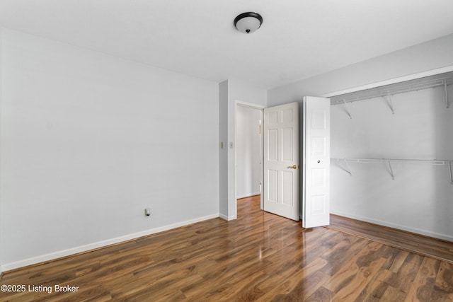 unfurnished bedroom with baseboards, a closet, and wood finished floors