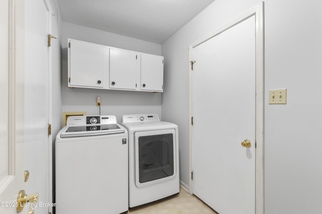 laundry room with cabinet space, a textured ceiling, and washing machine and clothes dryer