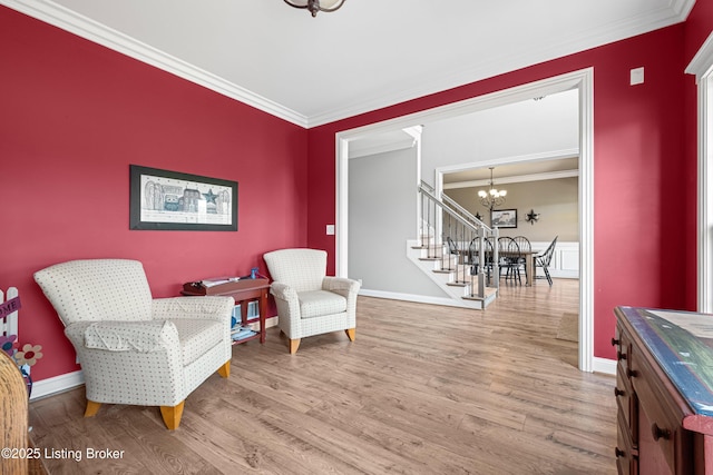 sitting room featuring crown molding, baseboards, wood finished floors, and a chandelier