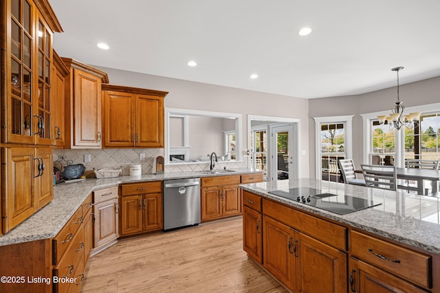 kitchen featuring brown cabinets, a sink, light wood finished floors, decorative backsplash, and stainless steel dishwasher