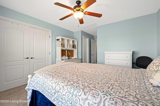 carpeted bedroom featuring a ceiling fan, a closet, and visible vents