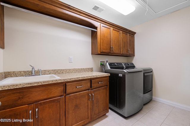 laundry room with visible vents, washing machine and dryer, cabinet space, a sink, and light tile patterned flooring