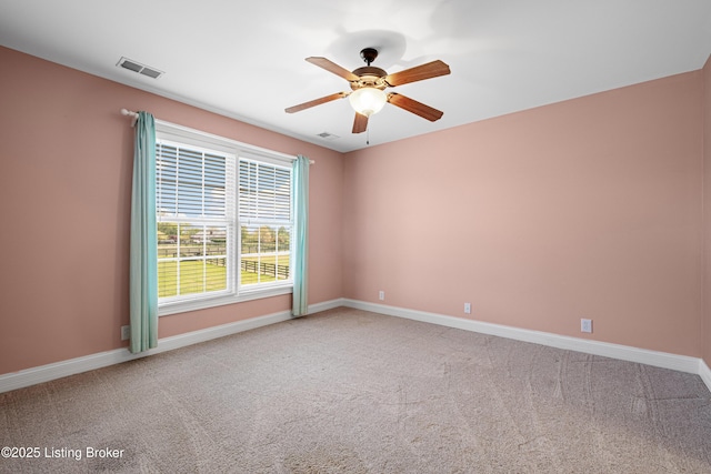 carpeted spare room featuring baseboards, a ceiling fan, and visible vents