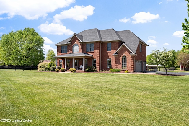 view of front facade featuring covered porch, brick siding, fence, a front lawn, and an attached garage