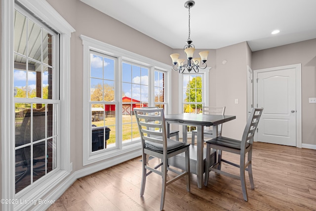 dining space with light wood-style floors, recessed lighting, baseboards, and a notable chandelier