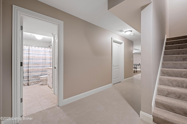 stairway with baseboards, visible vents, and carpet