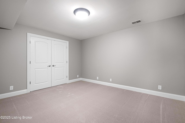 unfurnished bedroom featuring carpet floors, baseboards, visible vents, and a closet