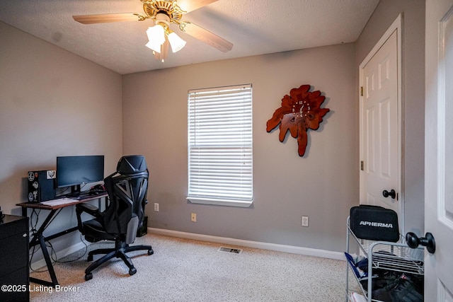 carpeted office space with baseboards, a ceiling fan, and a textured ceiling