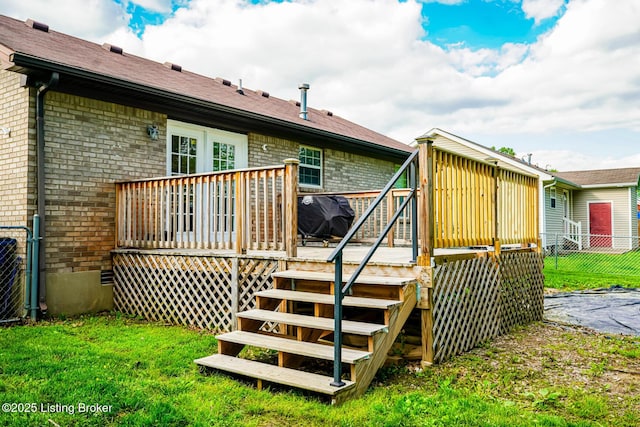 rear view of house featuring brick siding, a wooden deck, and stairs