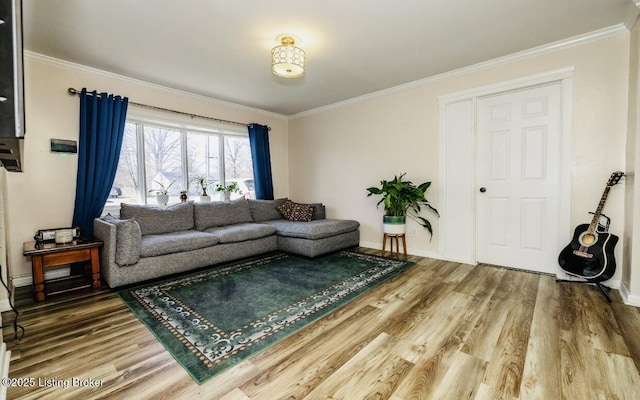 living area featuring crown molding, wood finished floors, and baseboards