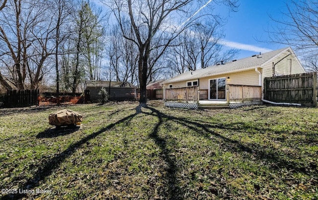 view of yard featuring a deck, a fire pit, and a fenced backyard