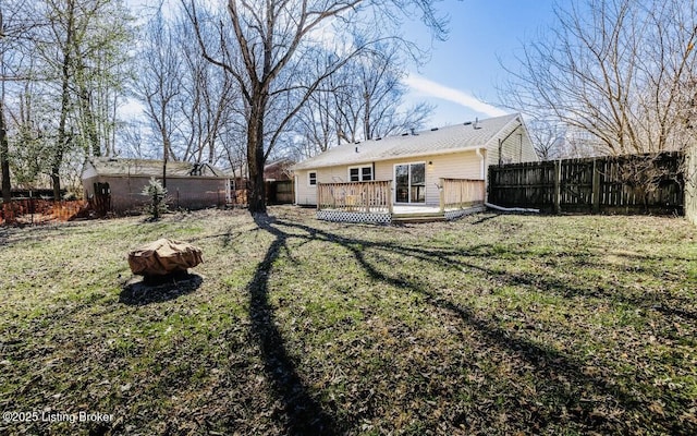view of yard featuring a deck, an outdoor fire pit, and a fenced backyard