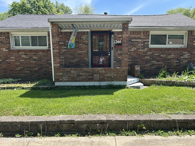bungalow-style home with a front yard and brick siding
