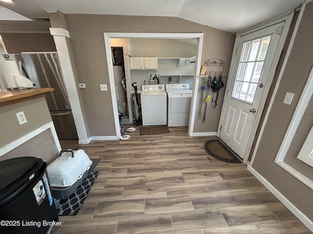washroom with independent washer and dryer, cabinet space, gas water heater, baseboards, and wood finished floors