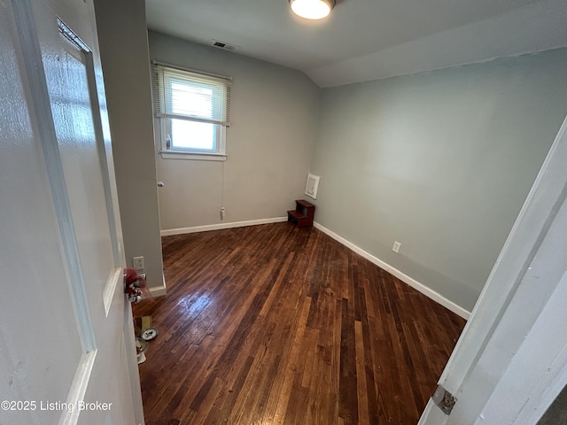 interior space with wood-type flooring, baseboards, lofted ceiling, and visible vents