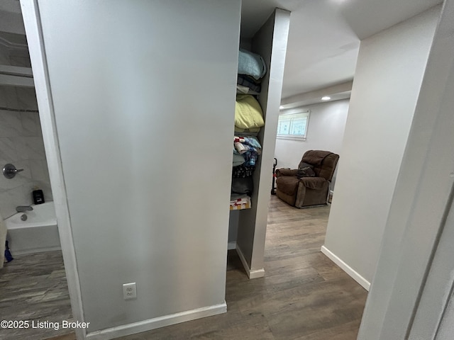 hall featuring baseboards and wood finished floors