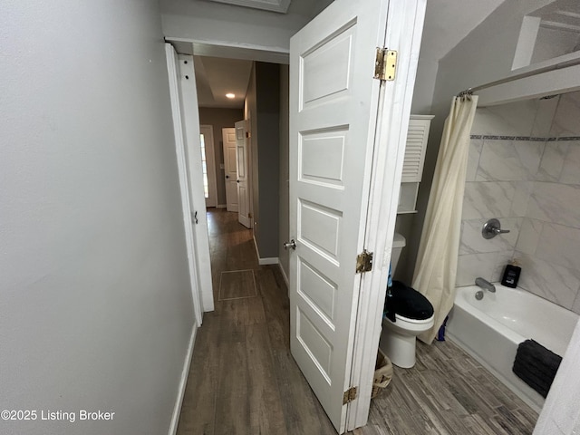 full bathroom with baseboards, shower / tub combo with curtain, wood finished floors, and toilet