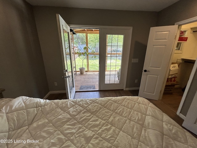 bedroom featuring baseboards, wood finished floors, and access to exterior