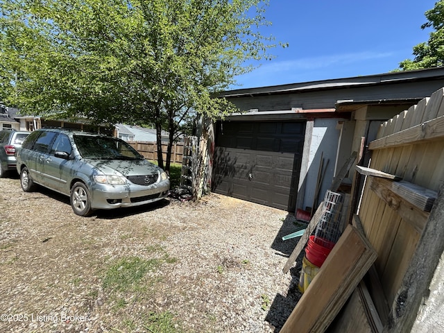 garage with fence and driveway