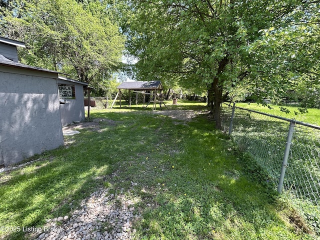 view of yard featuring fence and a carport