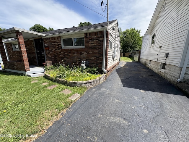 1244 Morgan Ave, Louisville, KY 40213 - view of side of property featuring brick siding, a lawn, and asphalt driveway