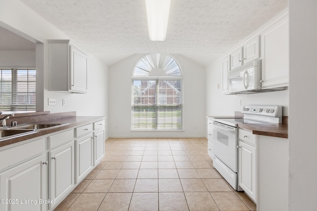 10436 Monticello Forest Cir, Louisville, KY 40299 - kitchen with lofted ceiling, dark countertops, white appliances, white cabinets, and a sink