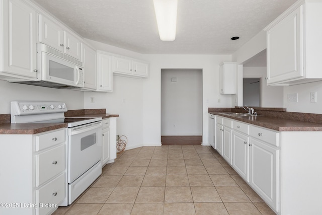 10436 Monticello Forest Cir, Louisville, KY 40299 - kitchen with dark countertops, white appliances, white cabinets, a sink, and light tile patterned floors