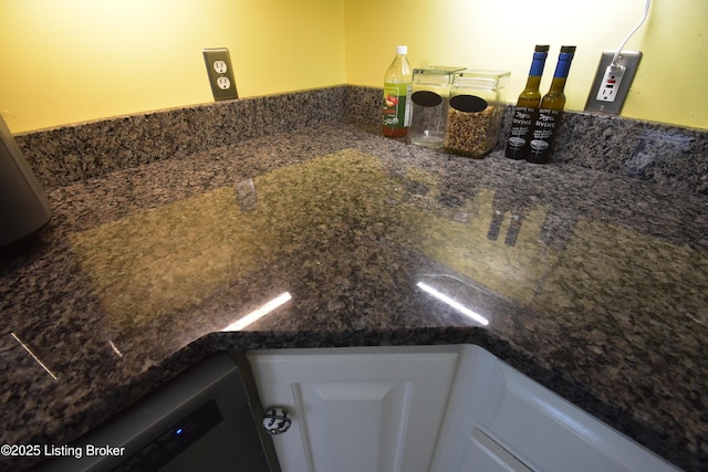 interior details with white cabinetry and dark countertops