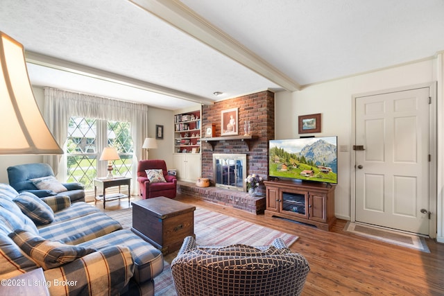 7103 Green Spring Dr, Louisville, KY 40241 - living area featuring beam ceiling, wood finished floors, a brick fireplace, and a textured ceiling