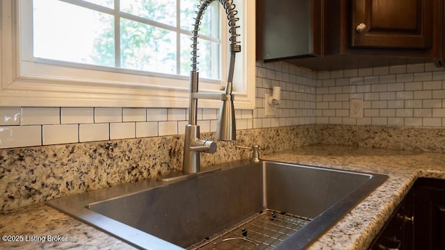 113 Chattanooga Dr, Coxs Creek, KY 40013 - interior details featuring tasteful backsplash, dark brown cabinets, light stone countertops, and a sink