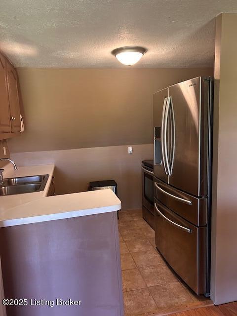 89 Peach St, New Haven, KY 40051 - kitchen featuring electric stove, a textured ceiling, stainless steel fridge with ice dispenser, and a sink