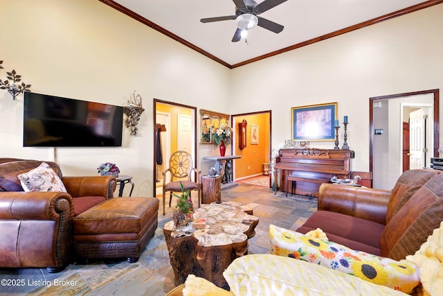 living room with a ceiling fan, crown molding, and a high ceiling