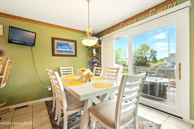 dining area featuring light tile patterned flooring, baseboards, and ornamental molding