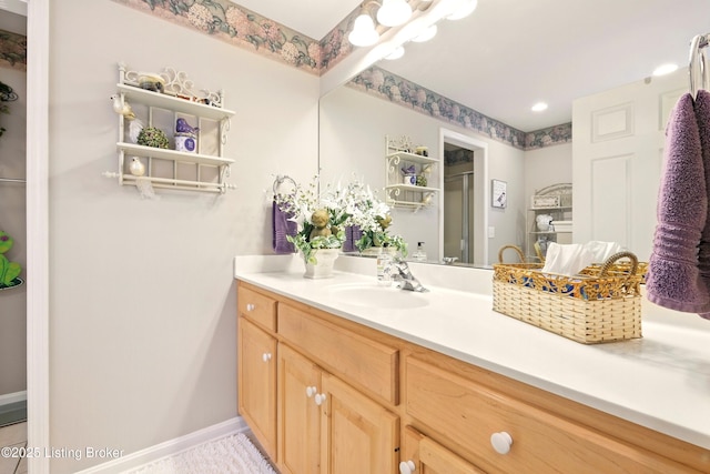 full bath with vanity, a shower stall, and baseboards