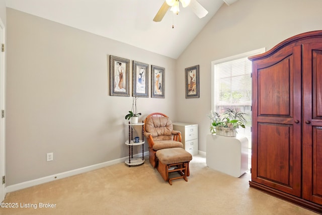 sitting room with ceiling fan, light colored carpet, high vaulted ceiling, and baseboards