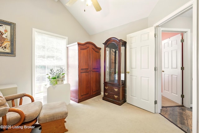 sitting room featuring healthy amount of natural light, vaulted ceiling, a ceiling fan, and light carpet