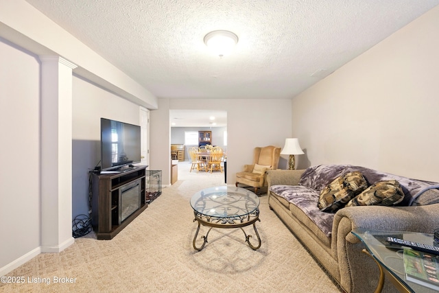 carpeted living room with a textured ceiling, a fireplace, and baseboards