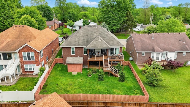 back of house with a wooden deck, stairs, brick siding, a storage shed, and an outdoor structure