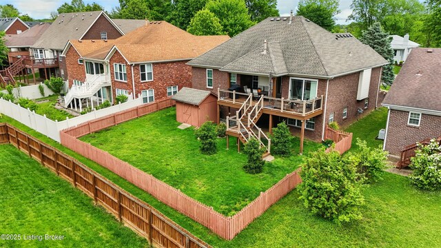 rear view of house featuring brick siding, a wooden deck, stairs, a storage unit, and an outdoor structure