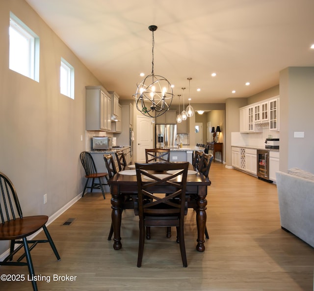 2854 Hamilton Springs Dr, Louisville, KY 40245 - dining area featuring a chandelier, light wood-style floors, recessed lighting, baseboards, and beverage cooler